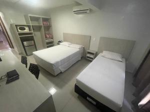 um quarto de hotel com duas camas e uma mesa em MIX APART Hotel em Brasília