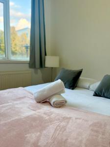 - une serviette blanche sur un lit avec une fenêtre dans l'établissement Bright Central London Apartments by DC London Rooms, à Londres