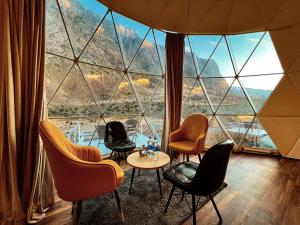 een kamer met stoelen en een tafel voor een groot raam bij YOLO Outdoors - Riverside Luxury Domes, Jispa in Jispa