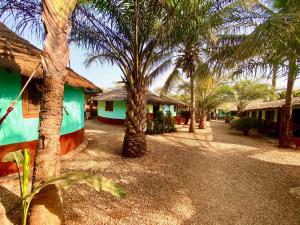 a row of palm trees in front of houses at MANGO LODGE in Bubaque