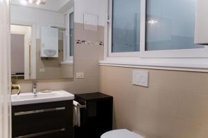een badkamer met een wastafel, een toilet en een raam bij Domus Oriana in Rome
