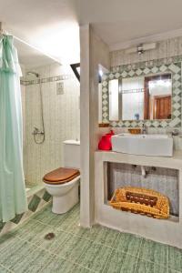 a bathroom with a toilet and a sink and a mirror at Villa Ntora in Afiartis