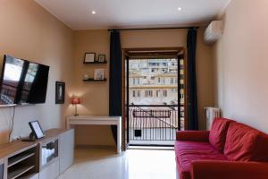 een woonkamer met een rode bank en een balkon bij Domus Oriana in Rome