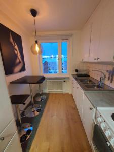 cocina con mesa, fregadero y ventana en Close to the subway. Beautiful and Cozy apartment!, en Estocolmo