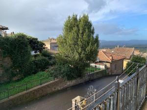 een brug over een straat met huizen en een boom bij Alloggio da Mary in Canale Monterano