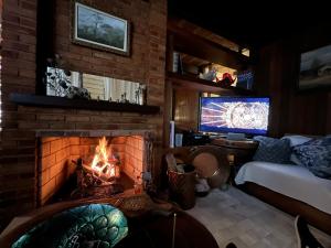 sala de estar con chimenea y TV en Casa Holanda en Teresópolis