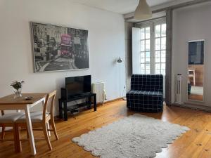 a living room with a table and a tv at Douro River Cozy Apartments in Porto