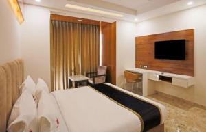 a hotel room with a bed and a flat screen tv at HOTEL Seven Heaven -Lawrence Road New Delhi in New Delhi