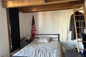 een bed met een Amerikaanse vlag in een slaapkamer bij Spacious House - near Parc des Beaumonts in Montreuil