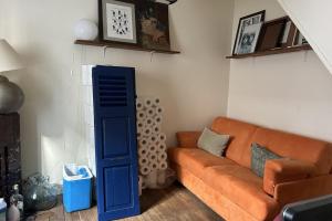 een woonkamer met een oranje bank en een blauwe deur bij Spacious House - near Parc des Beaumonts in Montreuil