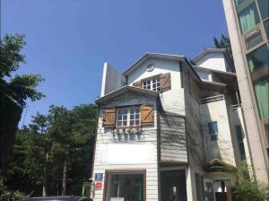 un antiguo edificio blanco con porche y ventanas en Art Residency en Busan