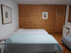 1 dormitorio con 2 camas y pared de madera en Art Residency en Busan