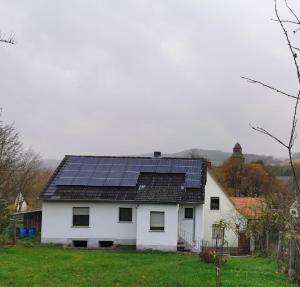 a white house with solar panels on the roof at Ferienhaus Lichtenberg in Herleshausen