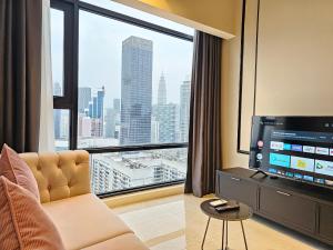 a living room with a television and a large window at The Axon Residence Bukit Bintang in Kuala Lumpur