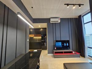 a living room with a television and a kitchen at The Axon Residence Bukit Bintang in Kuala Lumpur