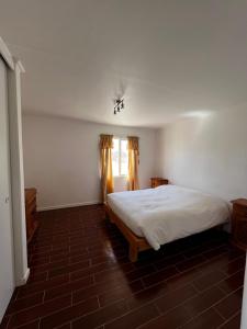 a bedroom with a white bed and a window at Hospedaje la Florentina in Pica