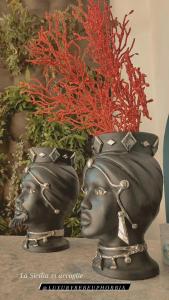 a statue of two heads with a vase at Luxury B&b Euphorbia in Acireale