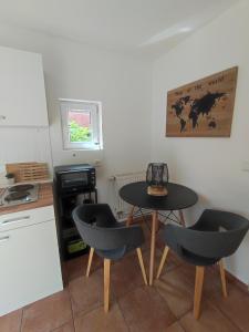 eine kleine Küche mit einem Tisch und zwei Stühlen in der Unterkunft AlteFeuerwache #2 in Husum