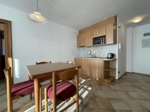a kitchen with a wooden table and a kitchen with a sink at 058 Trilocale Baldino, Pinzolo in Pinzolo