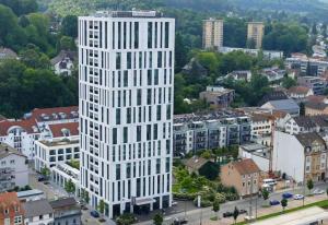 an overhead view of a tall white building in a city at Black Stone Apartments - Lörrach in Lörrach