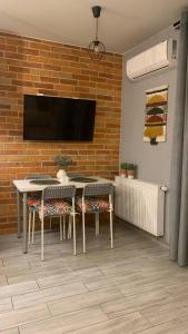 a room with a table and chairs and a wall with a tv at Roztocka studio, free parking, 1 tram to the city & PGE National Stadion, by Cosmo Spirit in Warsaw