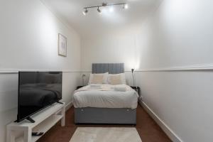 Schlafzimmer mit einem Bett und einem Flachbild-TV in der Unterkunft The Wilton in Glasgow