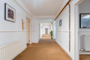 um corredor numa casa com paredes brancas e um longo corredor em The Wilton em Glasgow