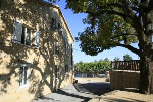uma sombra de uma árvore ao lado de um edifício em Domaine de la Pinède em Aubenas