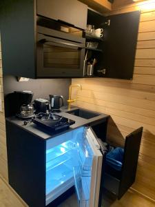 a small kitchen with a stove and a sink at Villa Auroras Kettu in Syöte