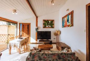 uma sala de estar com um sofá e uma televisão em Refúgio na natureza com vista espetacular em Ilhabela em Ilhabela