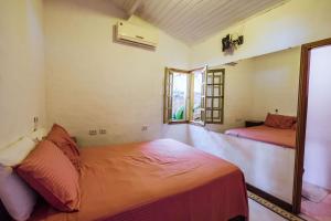 um quarto com uma cama e uma janela em Refúgio na natureza com vista espetacular em Ilhabela em Ilhabela