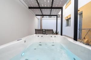 a large bath tub in a room with two chairs at La Casa Kos Center with Jacuzzi in Kos