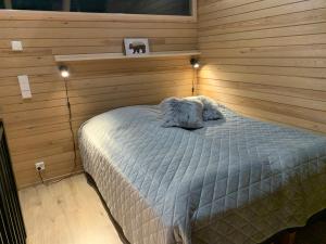 sypialnia z łóżkiem w drewnianej ścianie w obiekcie Villa Auroras Kettu w mieście Syöte