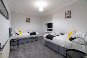 Bell Apartment في إيردري: سريرين في غرفة بجدران بيضاء