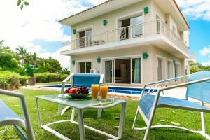 una mesa y sillas con un bol de fruta y zumo de naranja en Private Iberosta Villa Lagoon 4BDR- Private Beach and Pool, en Punta Cana