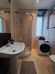 een badkamer met een douche, een wastafel en een wasmachine bij OMMP CENTRUM in Częstochowa