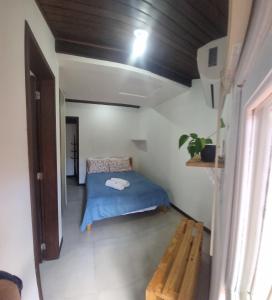 a small bedroom with a blue bed in a room at Jurerê Spécial Atlântico in Florianópolis