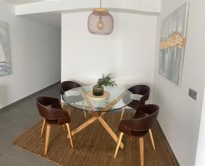 een eetkamer met een glazen tafel en stoelen bij Great apartment penthouse 2 bedrooms Tejita Beach in El Médano