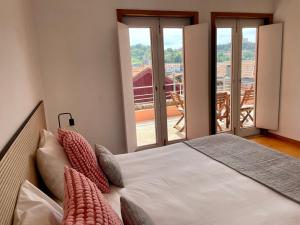 a bedroom with a bed with views of a balcony at Douro River Cozy Apartments in Porto