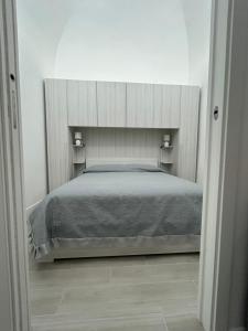 una camera da letto con un grande letto in una stanza bianca di Ciuri Holiday a Trapani