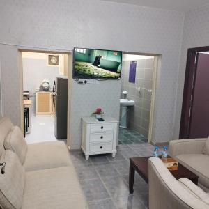 sala de estar con sofá y TV en la pared en العين الهيلي مصباح ب10, en Al Ain