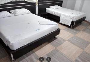 two twin beds in a room with at Hotel Sharey 