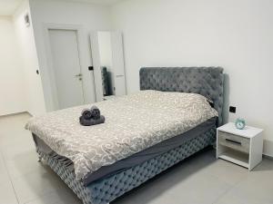 a bedroom with a large bed with a gray headboard at Luxury Centar in Arandelovac