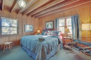 a bedroom with a bed in a room with wooden walls at Red Feather Lakes Cabin with Deck and Views! in Red Feather Lakes