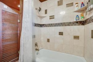 a bathroom with a tub and a shower with a shower curtain at Red Feather Lakes Cabin with Deck and Views! in Red Feather Lakes