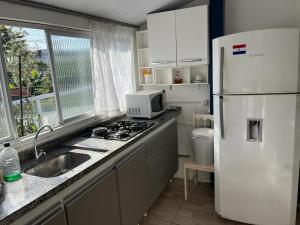 cocina con nevera blanca y fregadero en Residencial Varandas, en Florianópolis