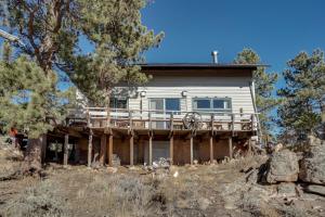 a house with a deck on a hill with trees at Red Feather Lakes Cabin with Deck and Views! in Red Feather Lakes