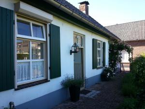 una casa con una puerta verde y una ventana en Oude woonboederij/old farmers house/typ. NL-Bauernhaus, en Zeddam