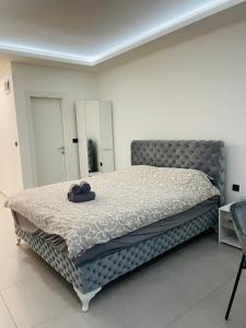 Luxury Centar في أراندجيلوفاك: غرفة نوم مع سرير مع قبعة عليه