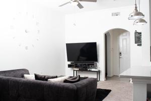 a living room with a couch and a flat screen tv at Midtown Contemporary Luxury 1BD-Pool-Gym-Patio-Office in Houston